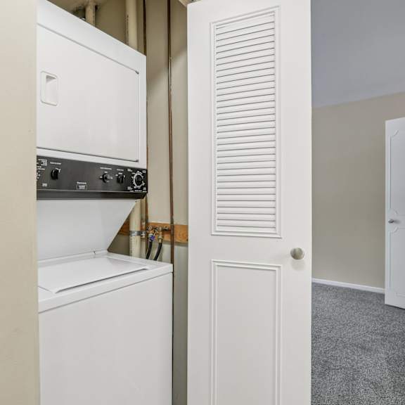 a white oven and microwave are built into a wall.