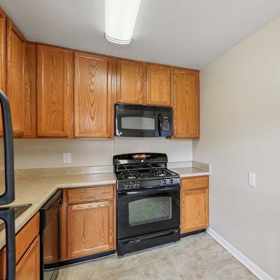a kitchen with wooden cabinets and a black stove top oven.
