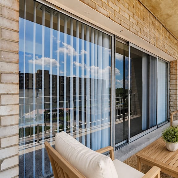 a balcony with a table and chairs overlooking a cityscape.