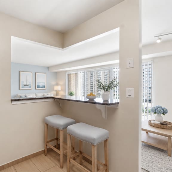 a kitchen with a bar stool and a framed picture on the wall.