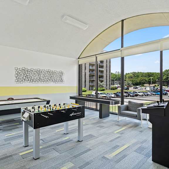 a billiard table is in the middle of a room with a black sofa and a black chair.