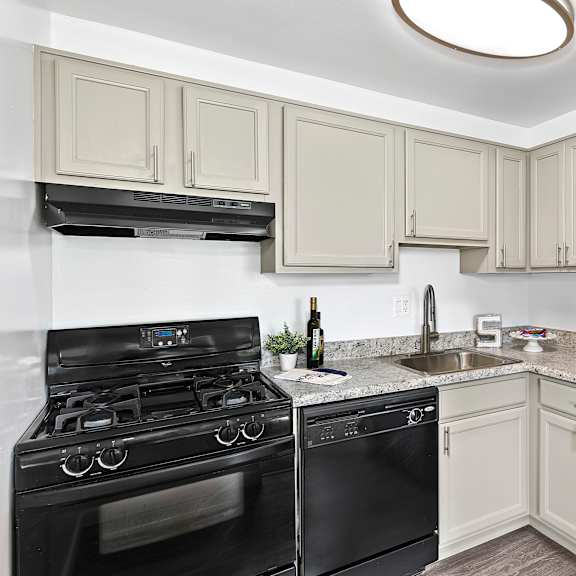 a kitchen with black appliances and white cabinets.