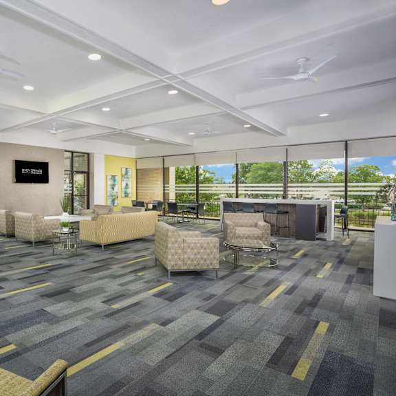 community space with gray carpeting and light green lounge chairs at seven springs apartments, maryland