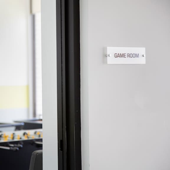 a foosball table is in a room with a sign that says game room.