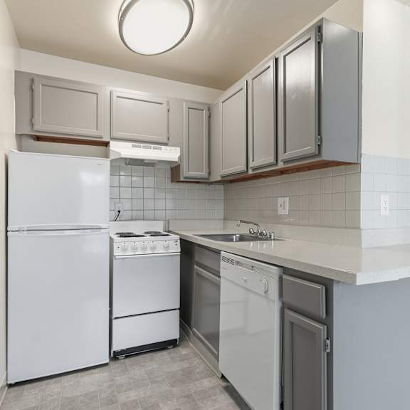 a kitchen with white appliances and grey cabinets.