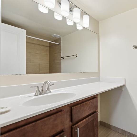 a white toilet is in a bathroom with a sink and mirror.