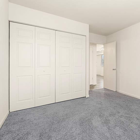 a room with white walls and a grey carpet at seven springs apartments, college park