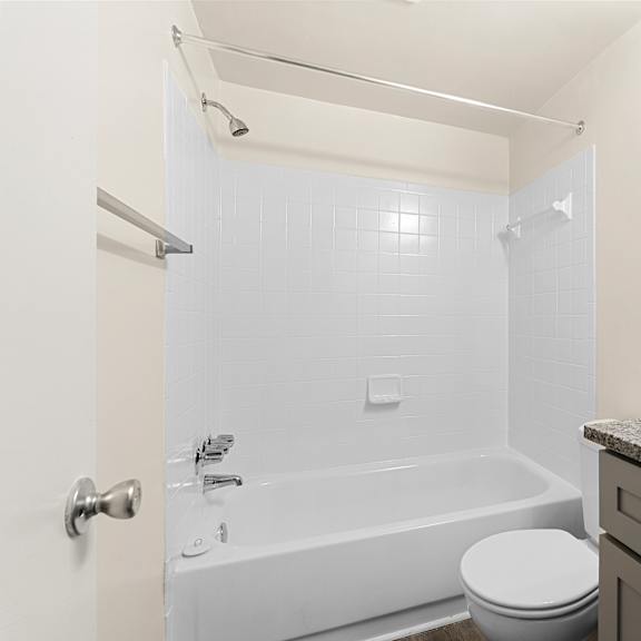 a white bathroom with a toilet, sink, and bathtub at seven springs apartments, college park