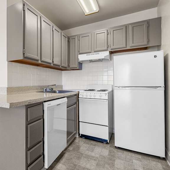 a kitchen with white appliances and grey cabinets.