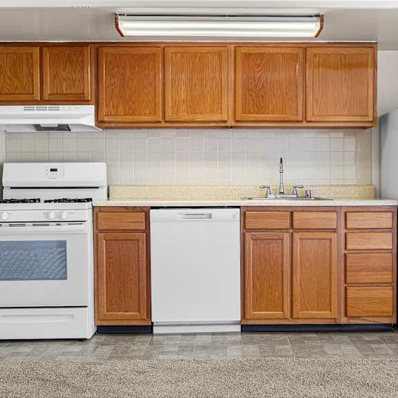 a kitchen with white appliances and wooden cabinets.