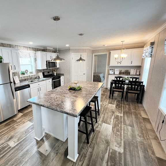 a kitchen with a large island and stainless steel appliances