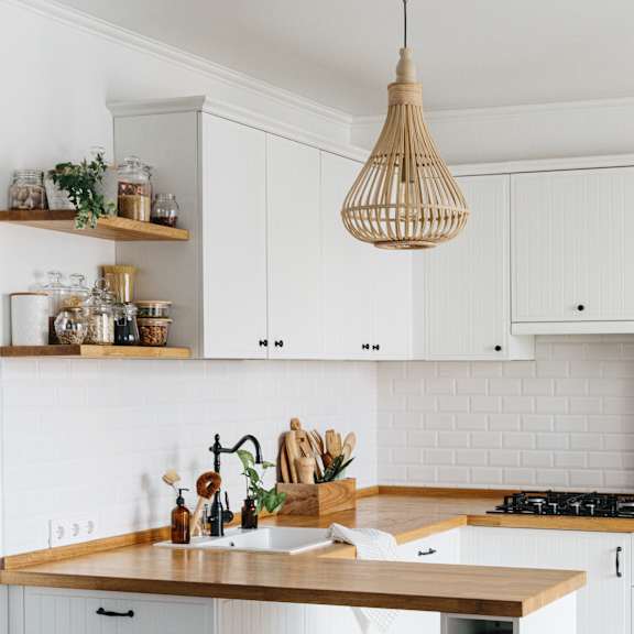 a kitchen with white cabinets and a wooden island.