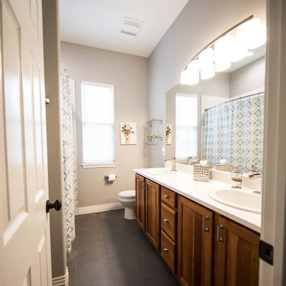 a bathroom with a large mirror and a sink and a toilet