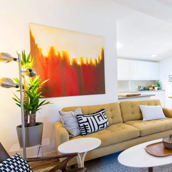 a living room with a yellow couch and two chairs