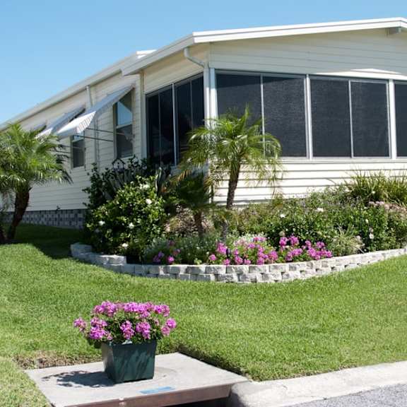 a house with a lawn and flowers in front of it