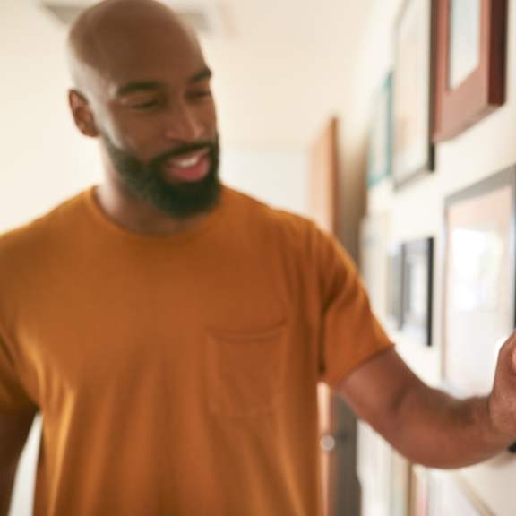 a man is looking at a thermostat on a wall