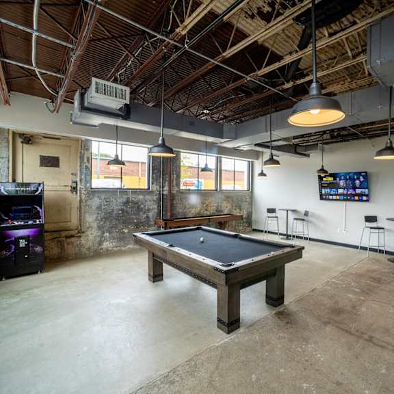 a pool table sits in the middle of a room with a tv in the background at conwood flats, memphis, tennessee
