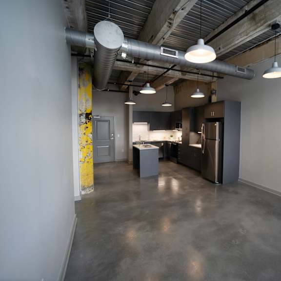 a kitchen and dining area in a room with concrete floors at conwood flats, memphis
