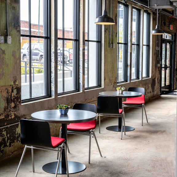 a row of tables and chairs in front of a wall of windows at conwood flats, memphis