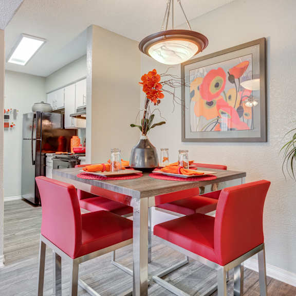 dining area with a table and chairs and a kitchen in the background at sausalito apartments, texas