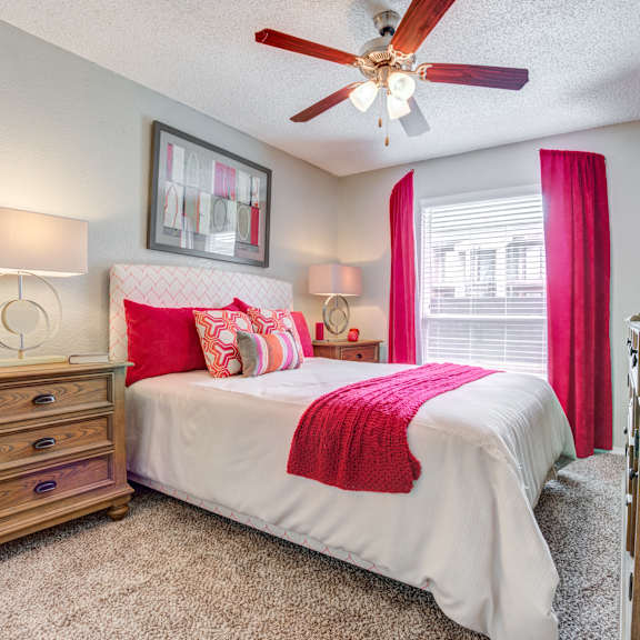 bedroom with a bed and a ceiling fan at sausalito apartments, college station, tx