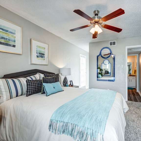 a bedroom with a bed and a ceiling fan at sundance apartments, college station