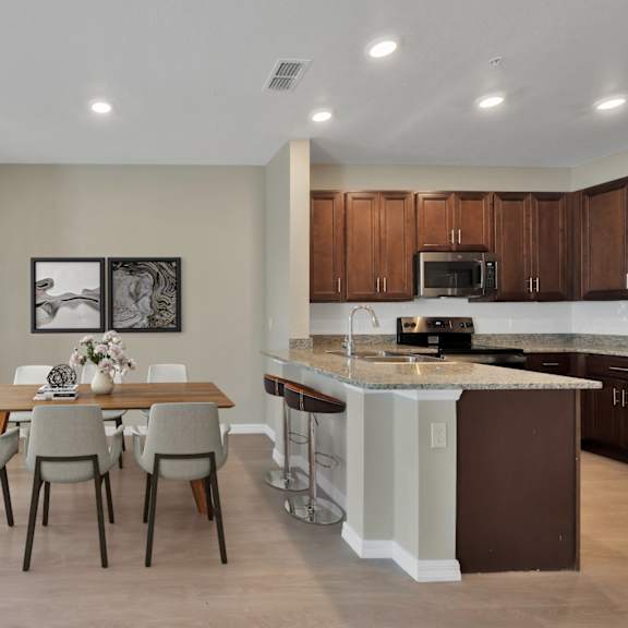 a dining area with a table and chairs next to a kitchen