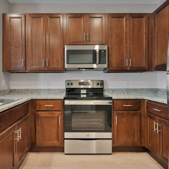 a kitchen with wooden cabinets and stainless steel appliances