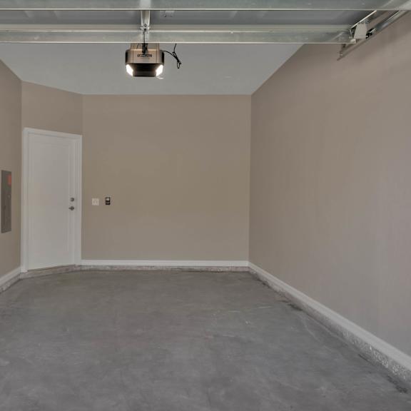 an empty room in a garage with a light on the ceiling