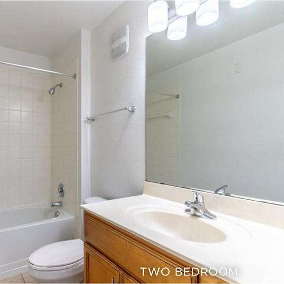 a white bathroom with a toilet, sink, and bathtub.