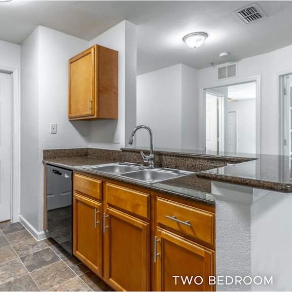 a kitchen with a sink, refrigerator, and cabinets.