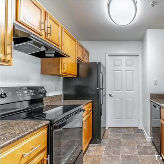 a kitchen with black appliances and wooden cabinets.