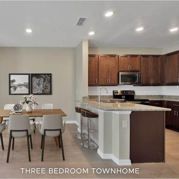 a kitchen with brown cabinets and a dining table with four chairs.