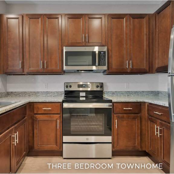 a kitchen with brown cabinets and a stainless steel refrigerator.