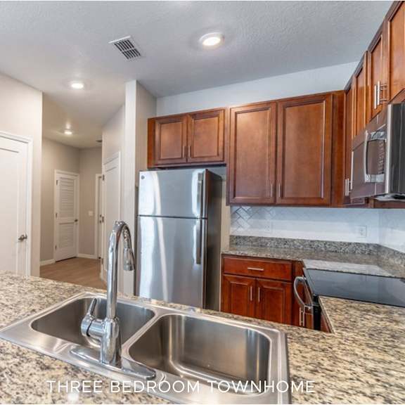 a kitchen with granite countertops and stainless steel appliances.