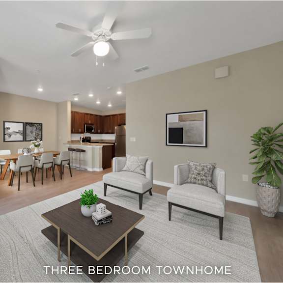 a living room with a grey couch, a coffee table, and a ceiling fan.