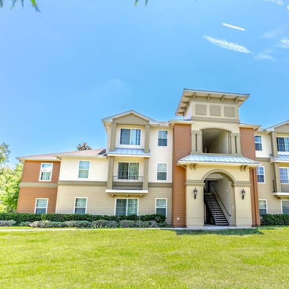 a large apartment building with a grassy area in front of it