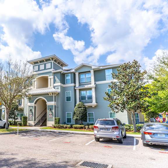 a large apartment building with a parking lot in front of it