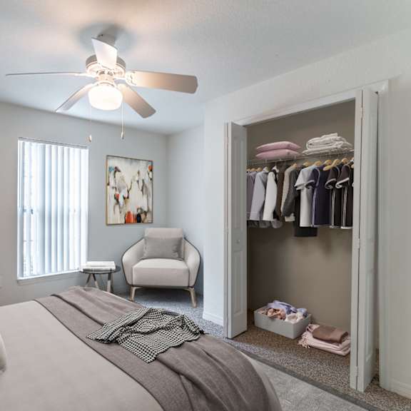 a bedroom with a ceiling fan and closet