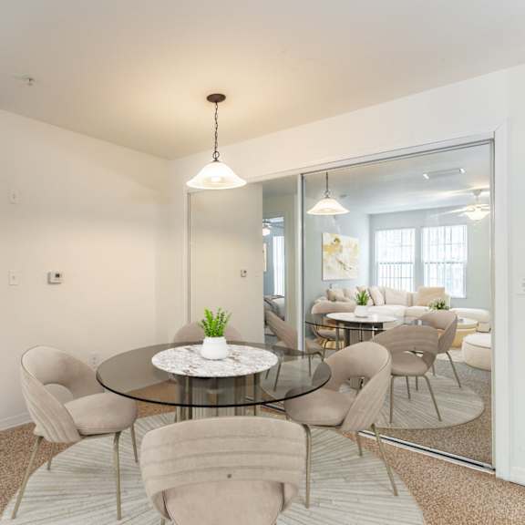 a dining room with a glass table and chairs