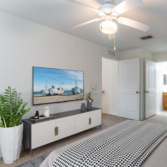 a bedroom with a large bed and a ceiling fan