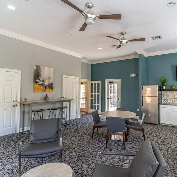 a room with a table and chairs and a kitchenette