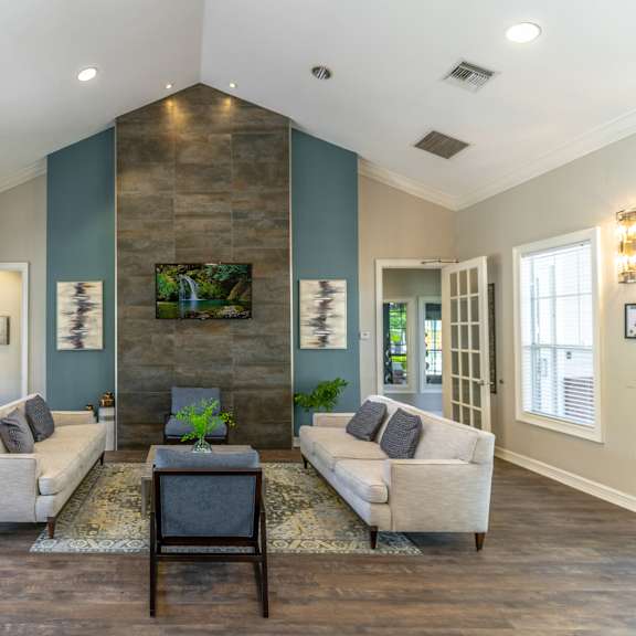 a clubhouse room with couches chairs tv and a coffee table