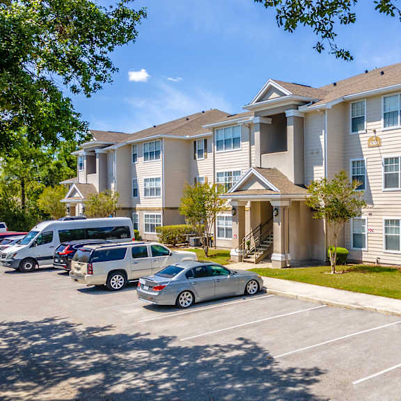a large apartment building with a parking lot in front of it