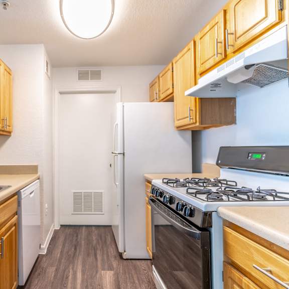 a kitchen with wood cabinets and white appliances