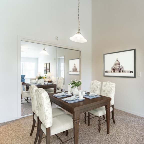 a dining room with a wooden table and white chairs