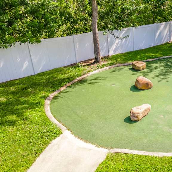 a mini golf court with rocks in the grass