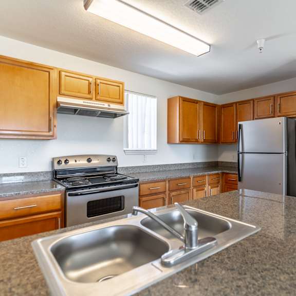 a kitchen with granite countertops and wooden cabinets