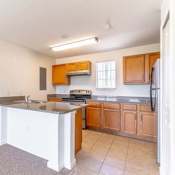 a kitchen with an island with granite countertops and wooden cabinets
