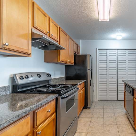 a kitchen with wooden cabinets and a black stove top oven.